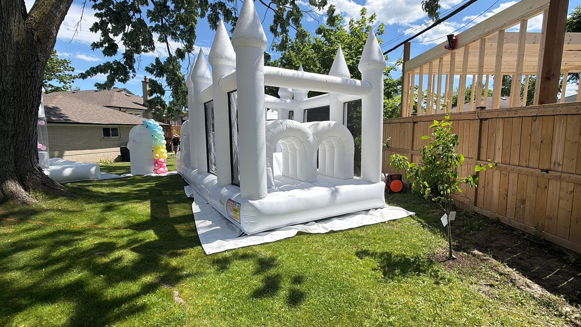 Colorful obstacle course with ball pit and waterslide, designed for kids' outdoor play by Aura Luxury Rental Ltd.