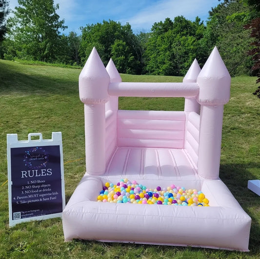Pink bounce house with attached ballpit for children, bright and colorful inflatable play structure by Aura Luxury Rental Ltd.